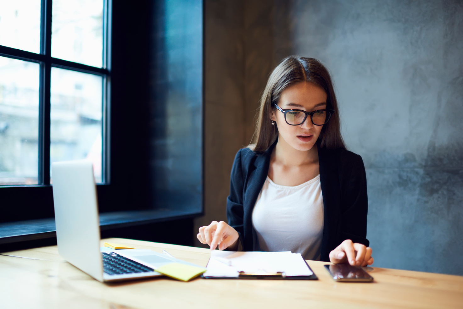 Busy confident female administrative manager in trendy eyewear